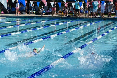 Outdoor swimming pool with lane dividers during competitive swim meet with spectators