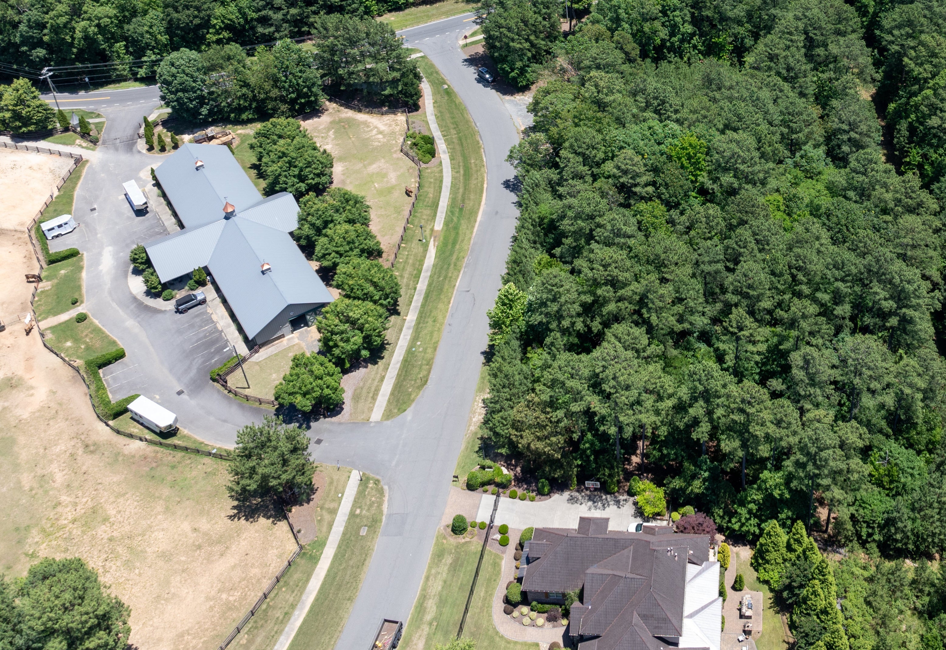 Aerial view of residential neighborhood with homes on wooded lots and curved streets