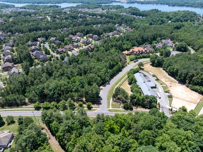 Aerial view of residential neighborhood with homes surrounded by trees near lakefront