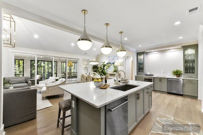 Open-concept kitchen and living room with gray island, white countertops, and pendant lighting