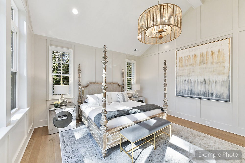 Master bedroom with four-poster bed, vaulted ceiling, hardwood floors, and wicker pendant light