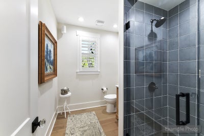 Bathroom with glass-enclosed shower featuring dark blue tile and black fixtures