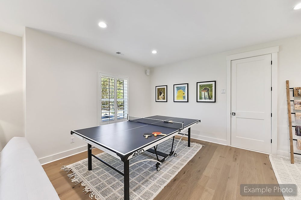 Recreation room with ping pong table, hardwood floors, and framed wall art