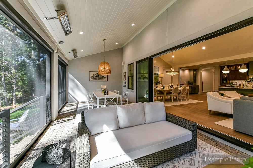 Screened porch with wicker furniture, ceiling fan, and sliding doors to dining room
