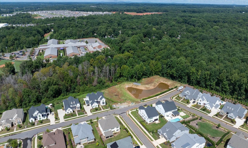 Aerial view of residential neighborhood with new homes and wooded surroundings