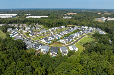 Aerial view of suburban residential neighborhood with single-family homes surrounded by trees