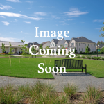 Two-story brick home with front lawn and driveway