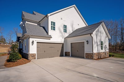 Two-story white home with stone accents and three-car garage