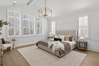 Bright bedroom with white plantation shutters, upholstered bed, and geometric pendant light fixture