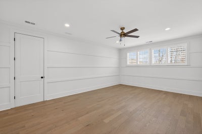 Empty room with white shiplap walls, light hardwood floors, and ceiling fan
