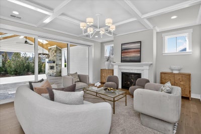 Living room with coffered ceiling, fireplace, and sliding doors to covered patio