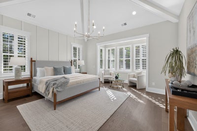 Master bedroom with vaulted ceiling, chandelier, plantation shutters, and hardwood floors