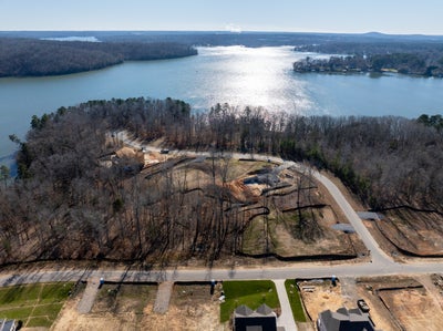 Aerial view of lakefront residential lots under development with wooded peninsula