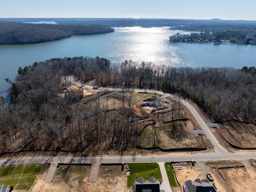Aerial view of lakefront residential lots under development with wooded peninsula