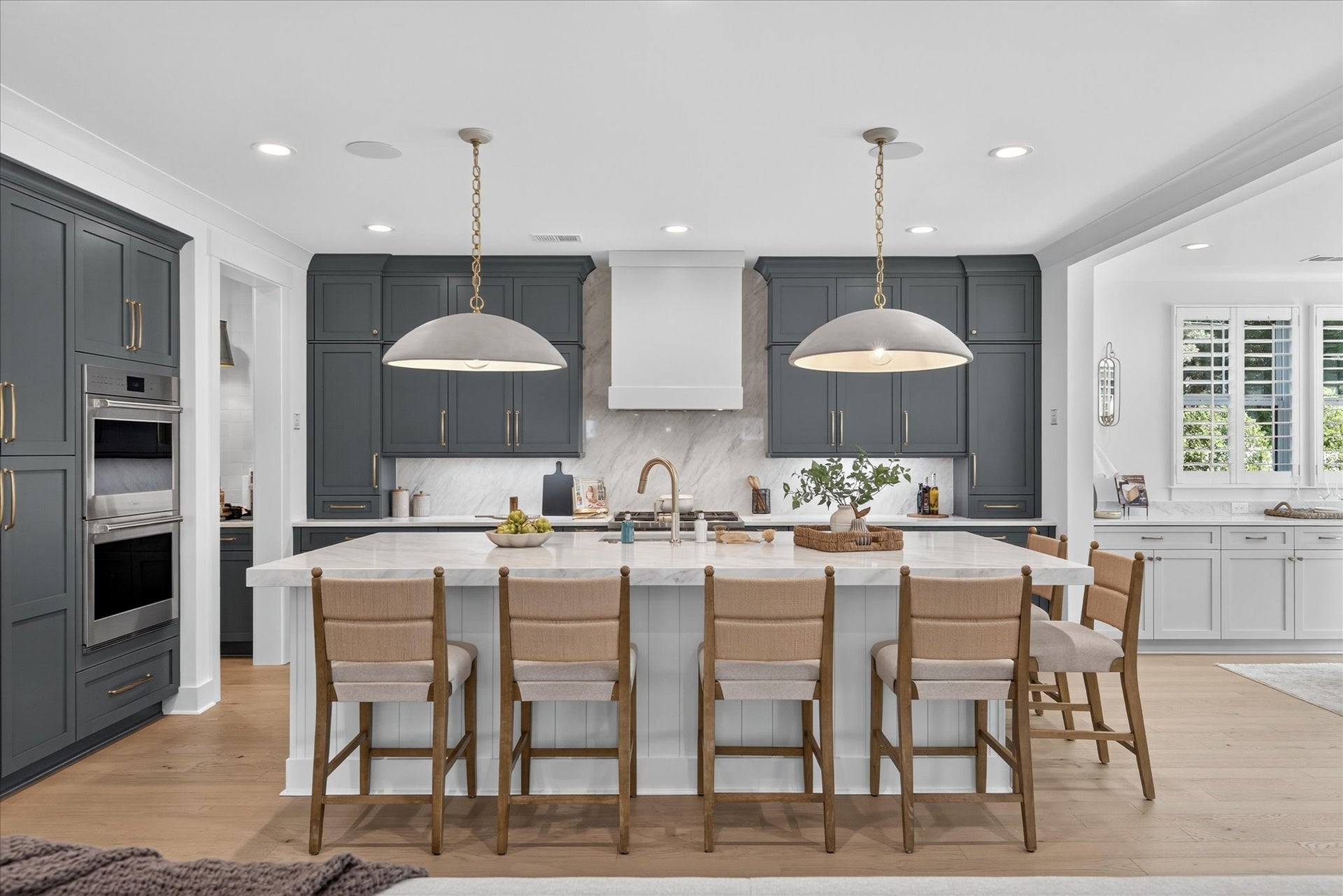 Modern kitchen with gray and white cabinets, large island with seating, and pendant lighting