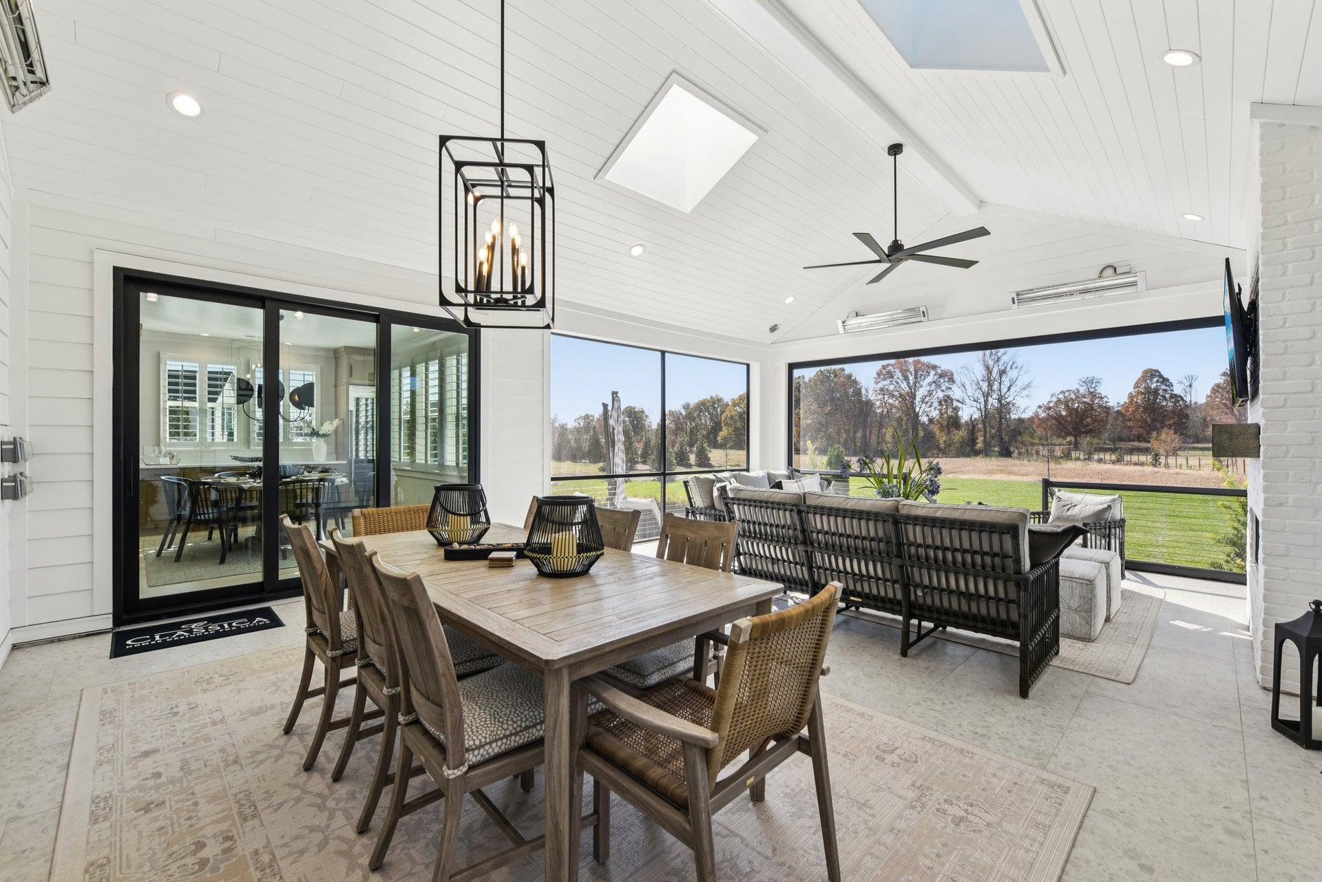 Covered patio with vaulted ceiling, dining table, and large windows overlooking golf course