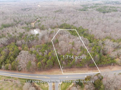 Aerial view of 1.714-acre wooded lot with road frontage and marked property boundaries