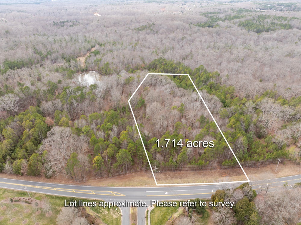 Aerial view of 1.714-acre wooded lot with road frontage and marked property boundaries