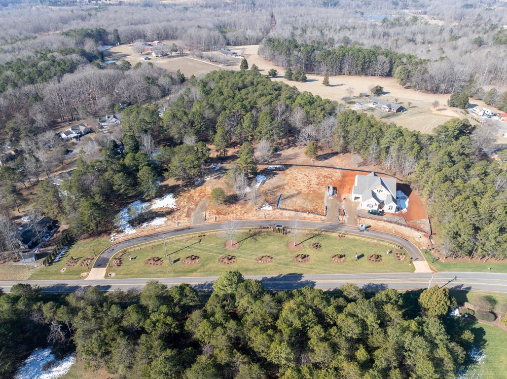 Aerial view of new home construction site on wooded lot in residential subdivision