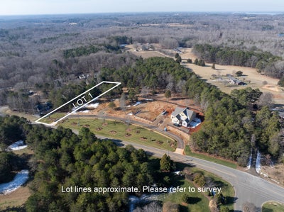 Aerial view of wooded building lot marked as Lot 1 in residential subdivision