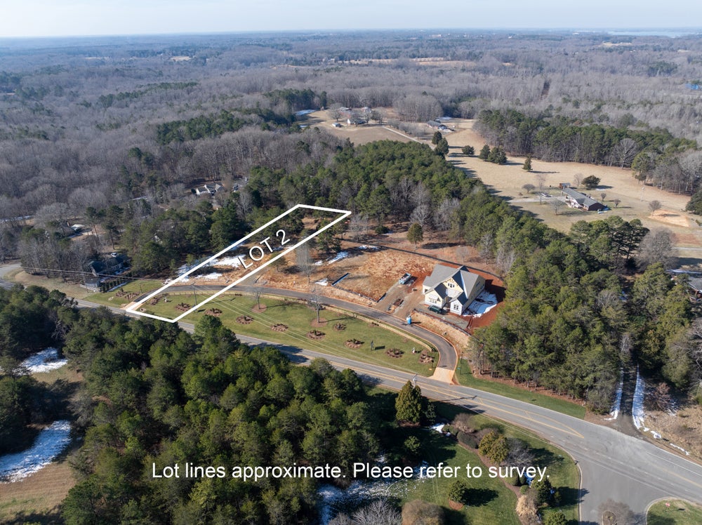 Aerial view of wooded building lot marked as Lot 2 in residential subdivision