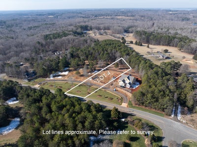Aerial view of residential lot with property boundaries marked, surrounded by trees and rural landscape