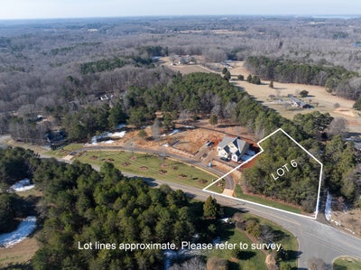 Aerial view of Lot 6 with new home under construction on wooded property