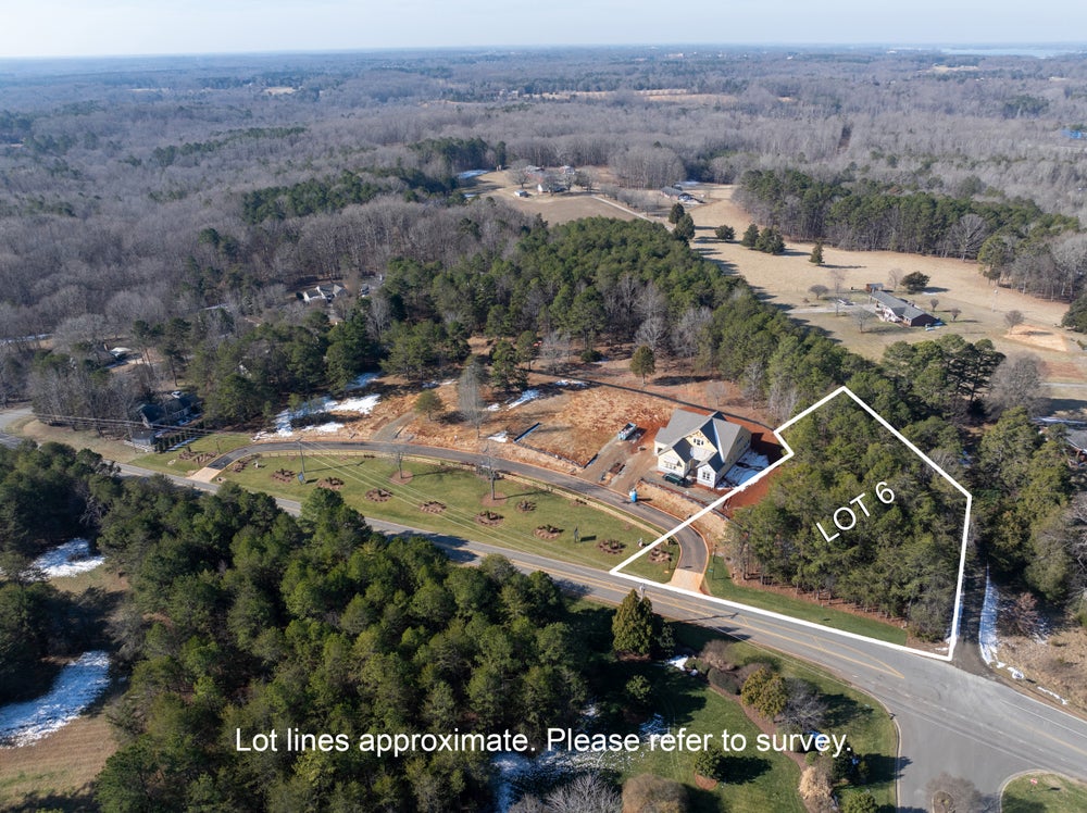 Aerial view of Lot 6 with new home under construction on wooded property