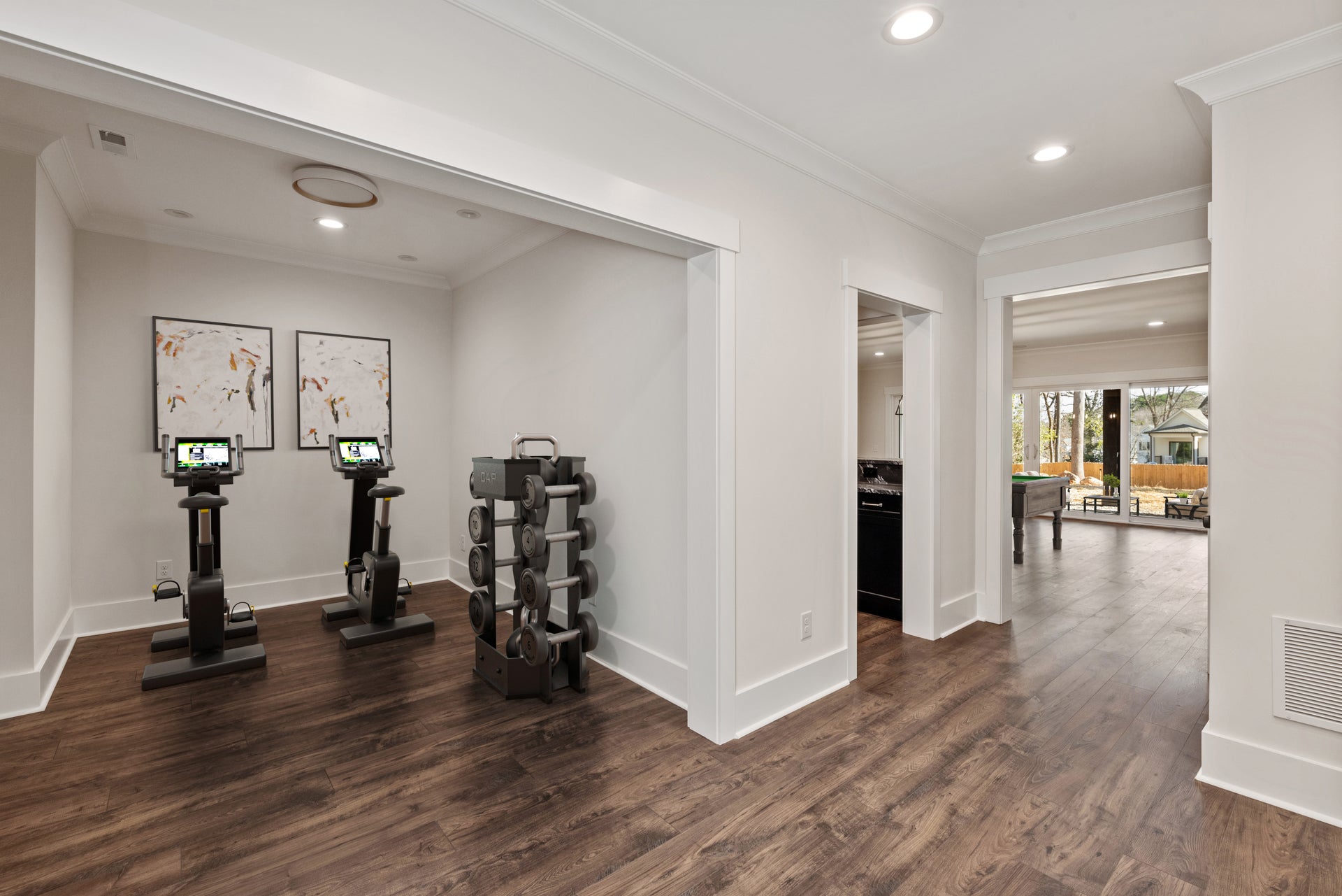 Home gym with exercise equipment, hardwood floors, and white walls