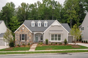 Single-story home with stone and siding exterior, three dormer windows, and covered front porch