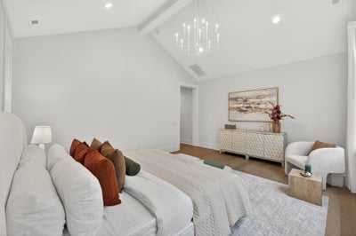 Spacious master bedroom with vaulted ceiling, chandelier, and white modern furnishings