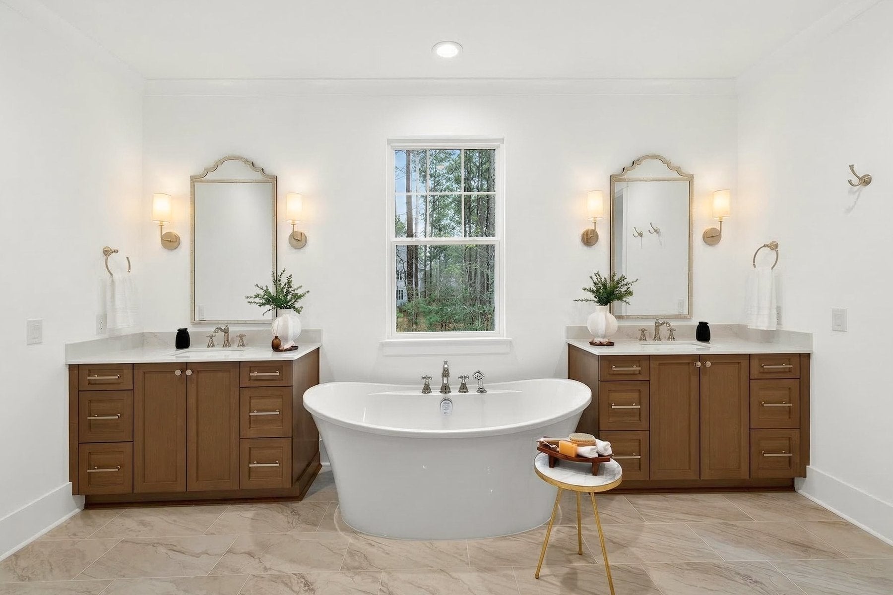 Master bathroom with freestanding tub, dual vanities with wood cabinets, and white countertops