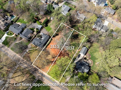 Aerial view of two adjacent vacant residential lots numbered 3133 and 3137 in established neighborhood
