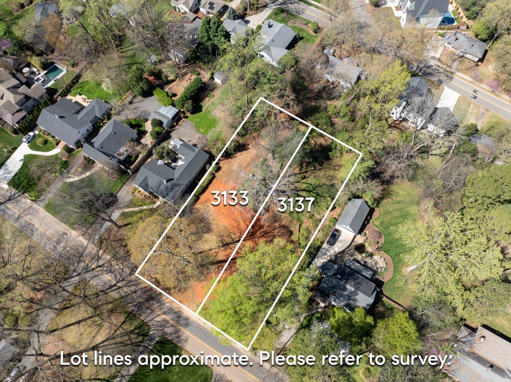 Aerial view of two adjacent vacant residential lots numbered 3133 and 3137 in established neighborhood