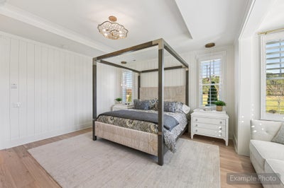 Bedroom with four-poster canopy bed, shiplap walls, hardwood floors, and tray ceiling with decorative light fixture