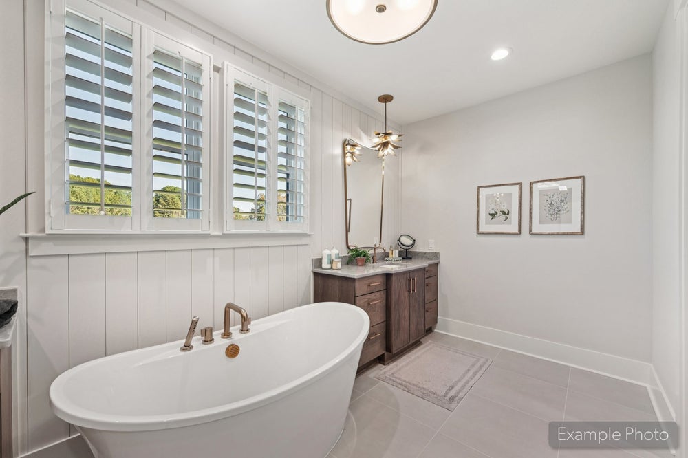 Bathroom with freestanding soaking tub, dark wood vanity, plantation shutters, and decorative pendant light fixture