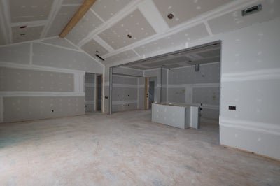 Unfinished basement with drywall installation and coffered ceiling under construction