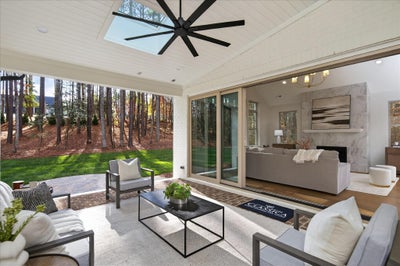 Covered patio with ceiling fan, outdoor furniture, and sliding glass doors to living room