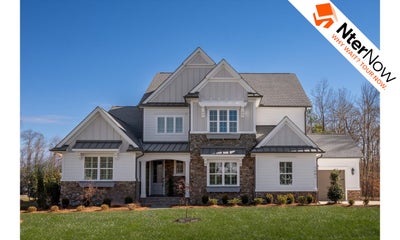 Two-story craftsman home with white board-and-batten siding, stone accents, and attached garage