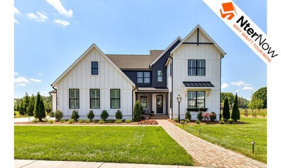 Two-story modern farmhouse with white board-and-batten siding, dark accents, covered porch, and brick walkway