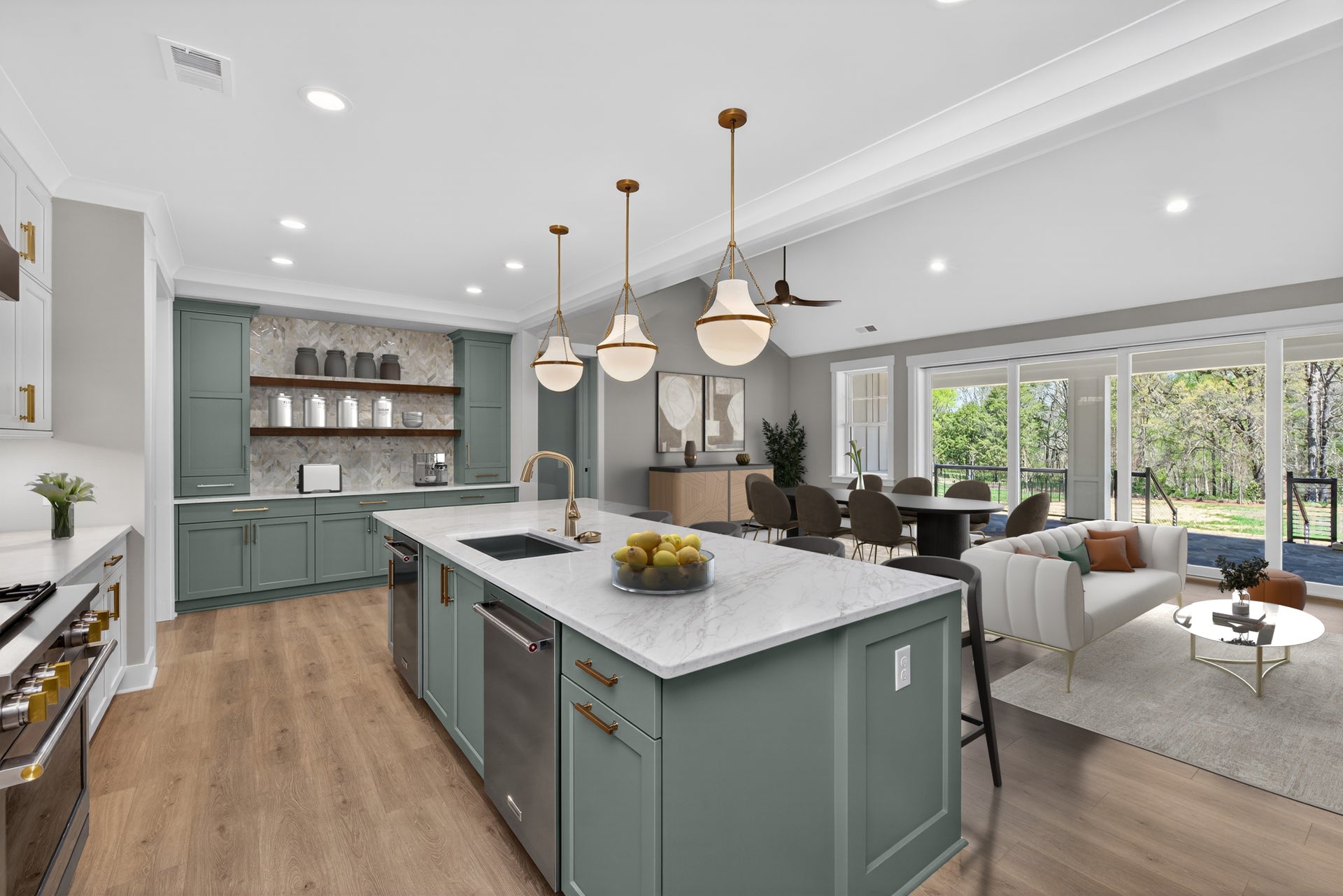 Open-concept kitchen with sage green cabinets, marble island, and pendant lights, flowing into dining and living areas with large windows.