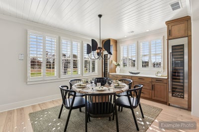 Dining area with round table, black chairs, shiplap ceiling, plantation shutters, and built-in wine cooler with wood cabinetry