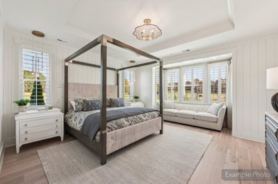 Bedroom with four-poster bed, shiplap walls, hardwood floors, and large windows with outdoor views