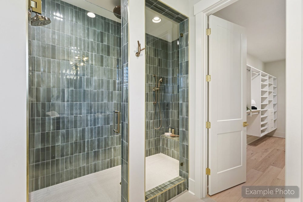 Two glass-enclosed showers with green tile walls and gold fixtures, adjacent to a walk-in closet with white shelving.