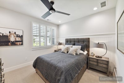 Bedroom with tufted headboard, shiplap accent wall, ceiling fan, and plantation shutters on window