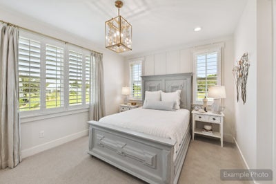 Bedroom with gray wood bed frame, plantation shutters, and gold pendant light fixture