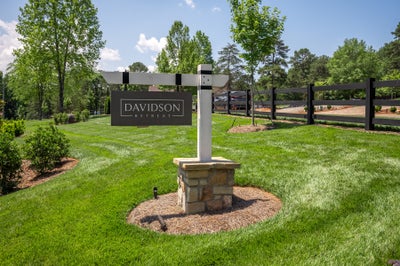 Davidson Retreat community entrance sign on stone base with green lawn and black fence in background