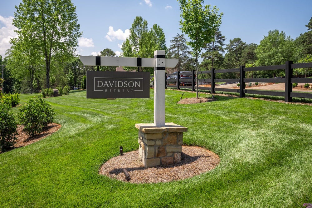 Davidson Retreat community entrance sign on stone base with green lawn and black fence in background