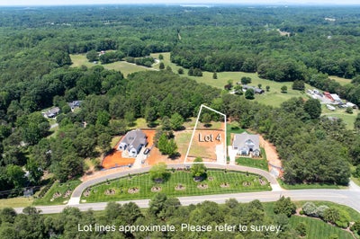 Aerial view of Lot 4 vacant residential lot between two new homes in a wooded suburban neighborhood