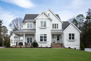 Two-story white farmhouse with board-and-batten siding, metal roof, covered porch, and green lawn